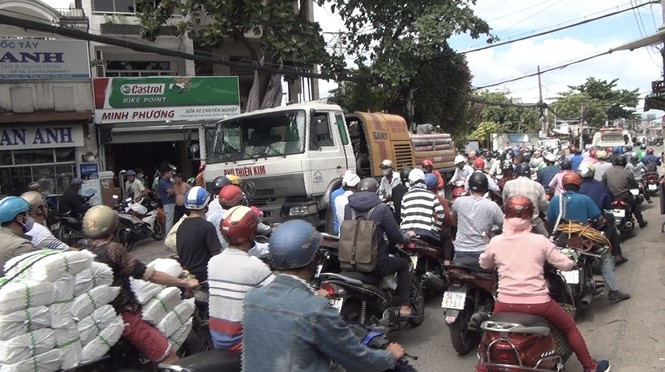 Tài xế Grabbike kẹt dưới bánh xe tải, giao thông ùn tắc nghiêm trọng - ảnh 1