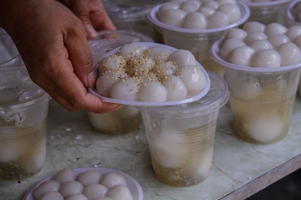 Dòng người xếp hàng dài trăm mét chờ mua bánh trôi, bánh chay. - ảnh 4
