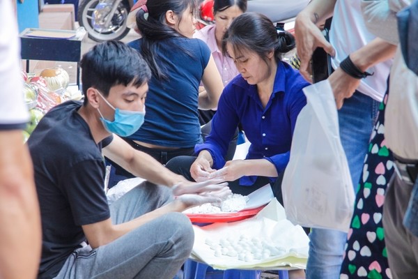 Dòng người xếp hàng dài trăm mét chờ mua bánh trôi, bánh chay. - ảnh 8