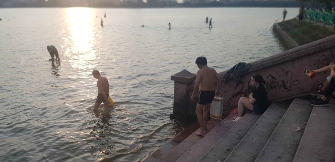 Người dân đổ ra Hồ Tây tắm, mặc cá chết bốc mùi tanh nồng - ảnh 2
