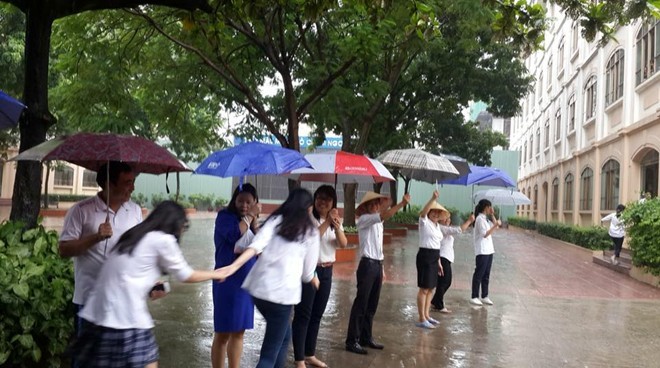 Thầy cô chịu ướt người, xếp hàng che mưa cho học sinh - ảnh 1