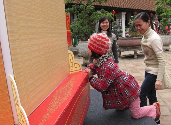 Một em bé xoay chiếc đèn kéo quân khổng lồ bên sân khấu chính