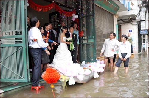 Trong trận lụt lịch sử tại Hà Nội năm 2008, đám cưới của chú rể Thành Khánh và cô dâu Minh Nguyệt ở khu Nam Đồng, quận Đống Đa, vẫn rộn ràng khi con phố đã ngập lênh láng. Ảnh: Facebook HN