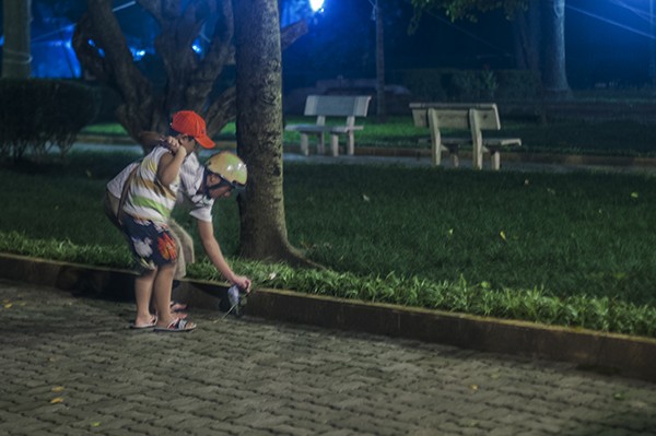 Một người cha đang cùng đứa con trai của mình đặt một bông hoa trong vườn nhà của Đại Tướng
