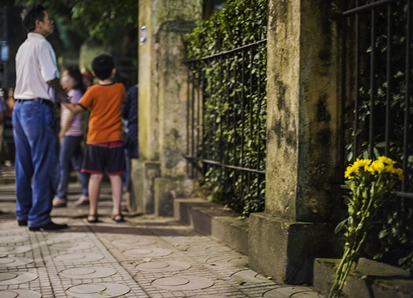 Một bó hoa cúc vàng được đặt trước hàng rào trước cửa nhà Đại Tướng