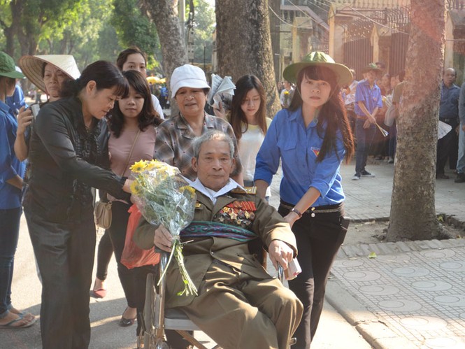 Người thương binh phải ngồi xe lăn nhưng vẫn muốn đến viếng Đại tướng với bó hoa Cúc vàng