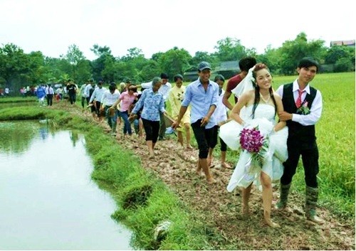 Đoàn rước dâu trên con đường đầy bùn đất, cô dâu chú rể cùng bà con hai họ phải xắn quần đi chân đất nhưng vẫn tươi cười lạc quan. Bức ảnh được cho là chụp ở một làng quê phía Bắc, đăng trên Facebook Thế giới teen