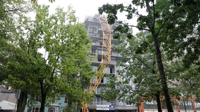Gặp bão Dorian, cần cẩu bất ngờ 'mềm như bún', đổ trúng nhà cao tầng - ảnh 1