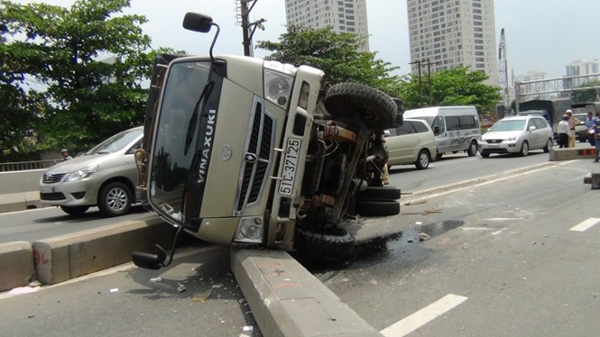 Xe tải tông dải phân cách, lật ngang trên cầu Sài Gòn - ảnh 1