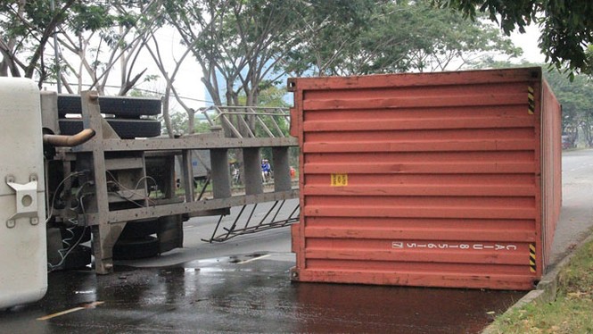 Container bất ngờ lật nhào, dầu nhớt lênh láng ra đường - ảnh 1