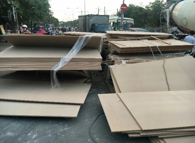 Giao thông hỗn loạn khi hàng trăm tấn ván ép trên container bung dây - ảnh 2