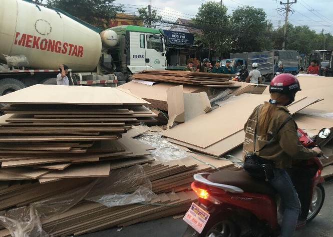 Giao thông hỗn loạn khi hàng trăm tấn ván ép trên container bung dây - ảnh 1
