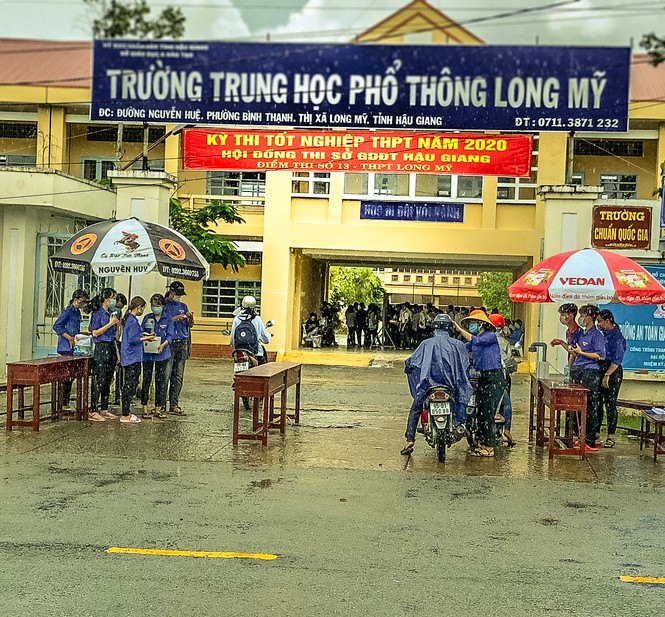 Cảm động tình nguyện viên dầm mưa hỗ trợ thí sinh thi tốt nghiệp THPT - ảnh 1