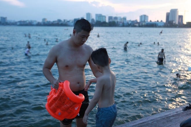 Nắng nóng, người dân đổ xô ra hồ Tây 'tắm biển' - ảnh 10