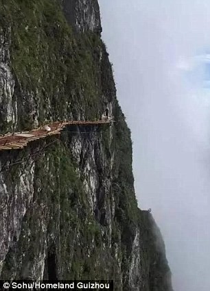 Hãi hùng công nhân Trung Quốc cheo leo trên vách núi xây cầu treo - ảnh 2