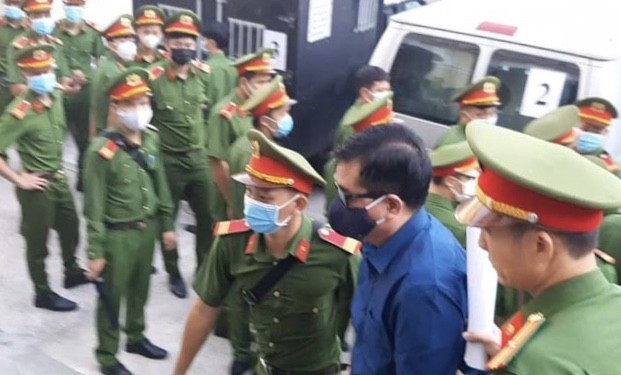 Áp giải cựu Bộ trưởng Đinh La Thăng vào tòa án sáng 14/12. Ảnh: Tân Châu