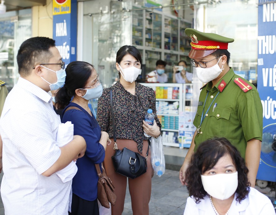 Lực lượng chức năng phường Hàng Trống (Hoàn Kiếm, Hà Nội) xử phạt người không đeo khẩu trang phòng dịch COVID-19 trước cổng bệnh viện Việt Đức ẢNH: như ý