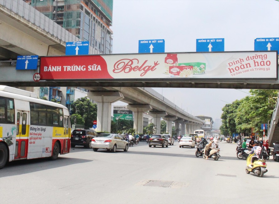 Quy định của thành phố Hà Nội, lắp biển quảng cáo mặt trong lan can để đảm bảo an toàn, nhưng các biển quảng cáo của Vinasing trên cầu vượt đã lắp ở mặt ngoài Ảnh: A.Trọng 