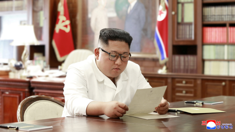 Chủ tịch Triều Tiên Kim Jong-un đọc thư của Tổng thống Mỹ Donald Trump. Ảnh: KCNA