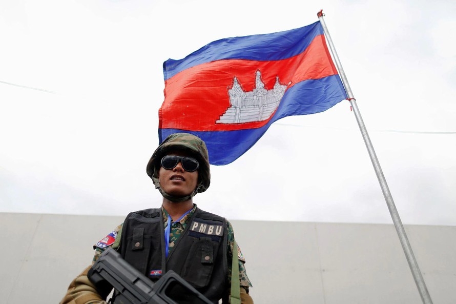 Quân nhân Campuchia đứng dưới quốc kì ở thủ đô Phnom Penh. Ảnh: Reuters