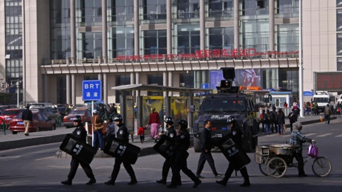 Cảnh sát mang vũ khí đi tuần bên ngoài nhà ga Tân Cương. Ảnh: SCMP