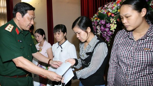 Trung tướng Nguyễn Hùng Mạnh, Chính ủy Bộ Tư lệnh Thủ đô, trao tiền hỗ trợ các gia đình. Ảnh: Trọng Đức/TTXVN