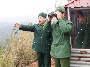 Thiếu tá An (trái) hướng dẫn chiến sĩ trẻ quan sát mục tiêu. Ảnh: N.M