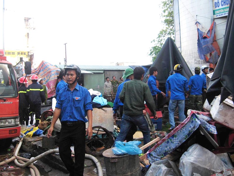 Áo xanh tình nguyện tham gia sơ tán, bảo vệ tài sản trong đám cháy. Ảnh: Phú Đức