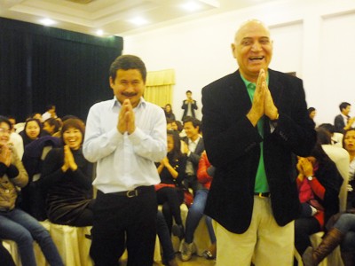Bác sĩ Madan Kataria (phải) và TS Phan Quốc Việt, Chủ tịch Hội đồng Giáo dục Tâm Việt Group (trái) cùng mọi người tập luyện bài cười mở lòng