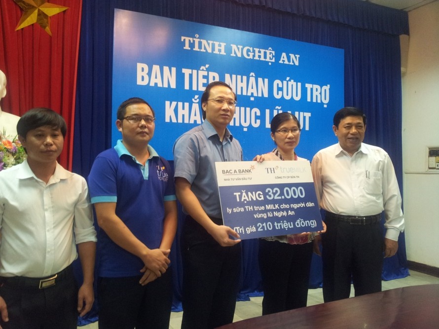 Chủ tịch tỉnh Nghệ An (ngoài cùng bên phải) tiếp nhận hàng cứu trợ lũ lụt của TH True Milk và Cty Văn Minh.
