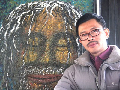 Họa sỹ Võ Trịnh Biện bên tác phẩm của mình