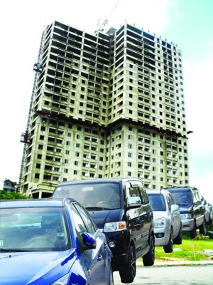 Một cao ốc dành cho người thu nhập thấp (ảnh trên) Đoàn xe của những người đi đăng ký mua nhà dành cho người thu nhập thấp ở Hà Nội) (ảnh dưới)