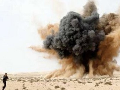 Một dân binh bịt tai khi bom của lực lượng thân Gadhafi nổ bên ngoài thành phố Brega Ảnh: Reuters