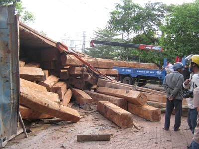 Lật xe container, hàng chục khối gỗ đổ ra đường