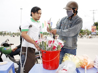 Nguyễn Văn Quang (trái) bán hoa gây quĩ từ thiện Ảnh: N.T