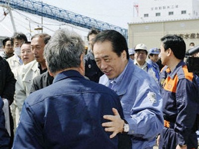 Thủ tướng Naoto Kan nói chuyện với quan chức thủy sản tỉnh Miyagi ngày 10-4 khi thăm một cảng cá ở địa phương này bị động đất, sóng thần tàn phá Ảnh: Kyodo