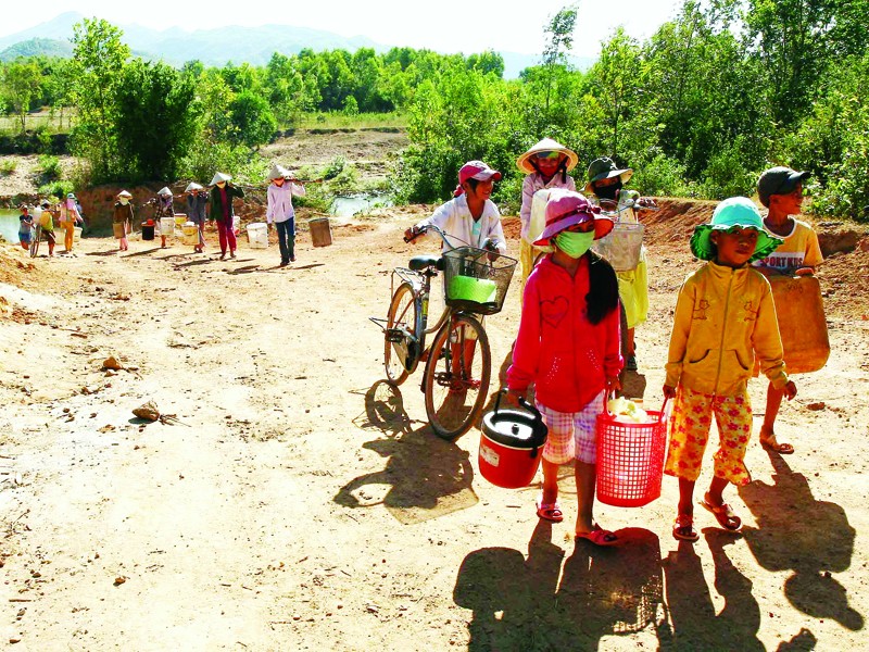 Nắng nóng gây ra tình trạng thiếu nước nghiêm trọng tại xã Cam Tuyền, Cam Lộ, Quảng Trị. Trong ảnh: Người dân đi lấy nước. Ảnh: TTXVN