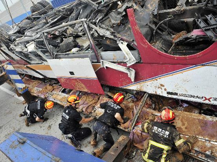 Cảnh sát và lực lượng cứu hộ thu dọn các mảnh vỡ của chiếc xe buýt lao từ trên cầu xuống đất tại Incheon, Hàn Quốc