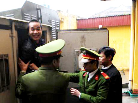 Đặng Trần Hoài tươi cười khi bước ra khỏi xe thùng tại sân tòa