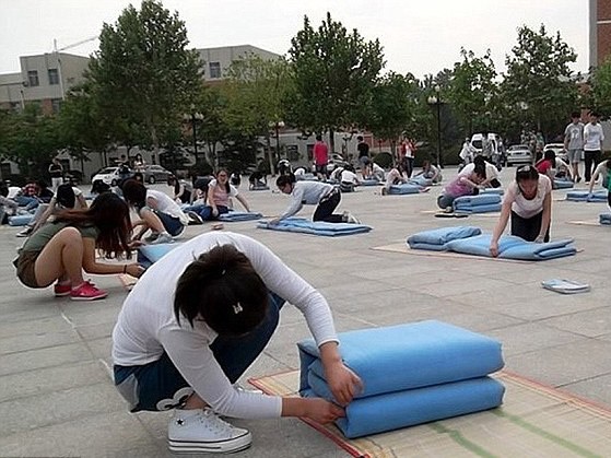 Các sinh viên tham gia vào cuộc thi gấp chăn để được vào kí túc xá ở Trung Quốc