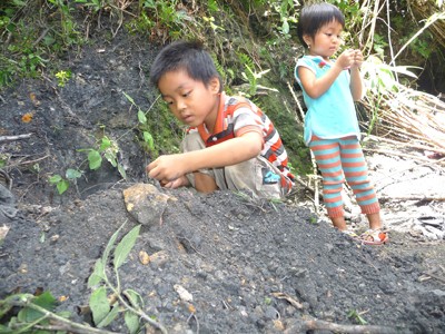 Trẻ em thôn 3 Tiên An chơi đùa bên vùng đất đen. Ảnh: N.T