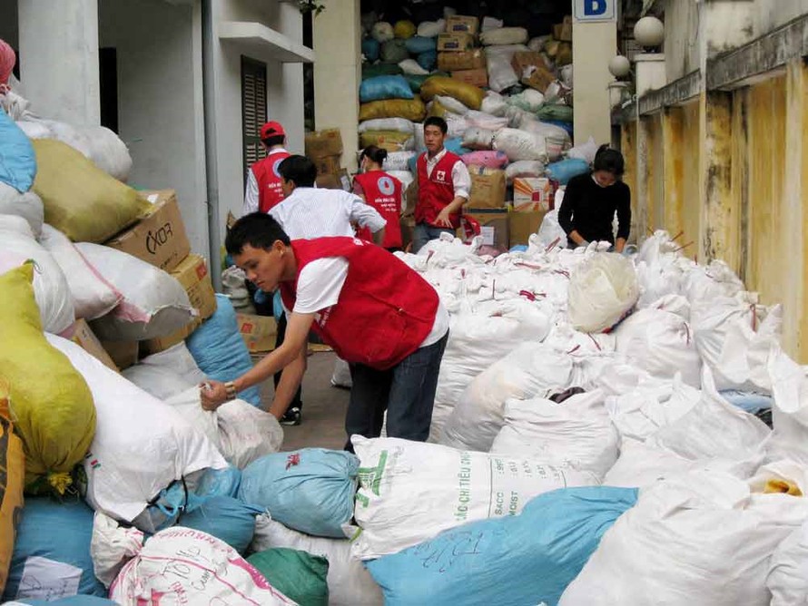 Sắp xếp, phân loại quần áo quyên góp cứu trợ cho miền Trung tại TƯ Hội Chữ thập đỏ VN. Ảnh: Bee.net