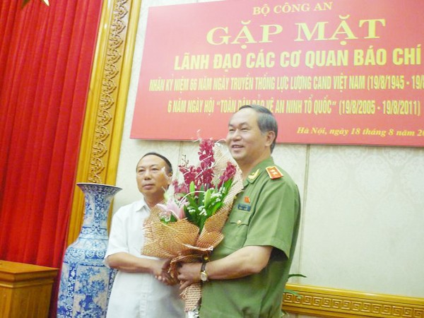 Bộ trưởng Trần Đại Quang (phải) nhận hoa chúc mừng do ông Hoàng Hữu Lượng (Cục trưởng Cục Báo chí, Bộ TT&TT) tặng