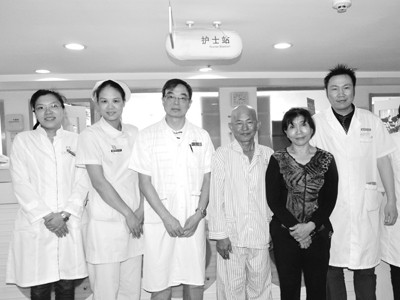 Bệnh nhân và vợ chụp ảnh cùng các bác sĩ điều trị