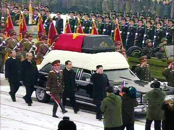 Người kế tục Kim Jong-un (thứ 5 từ trái) đi cạnh quan tài cha. Ảnh: Reuters