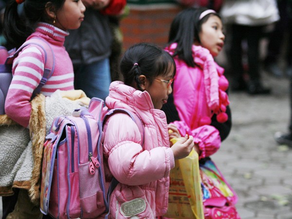 Học sinh tiểu học ở nhiều thành phố lớn phải mang cặp sách nặng. Ảnh: Hồng Vĩnh