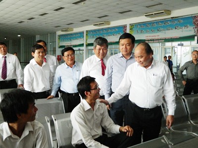 Phó Thủ tướng Nguyễn Xuân Phúc và Bộ trưởng GTVT Đinh La Thăng thăm hỏi hành khách chờ mua vé tàu Ảnh: LT