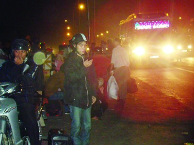 Nhiều công nhân ra đường đón xe về quê trong đêm 26-1 Ảnh: Đ.M