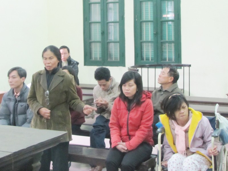 Nguyệt (ngồi xe lăn) cùng mẹ (người đang đứng) tại phiên xử hôm qua