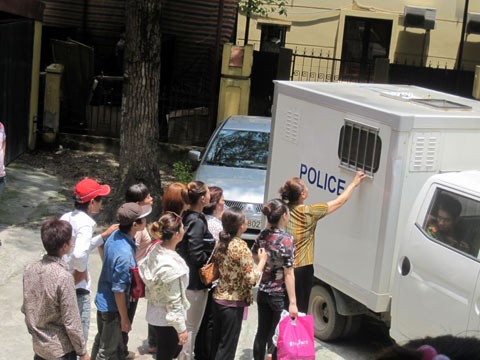 Người nhà các bị cáo cố nói chuyện với các con sau thùng xe cảnh sát bít bùng